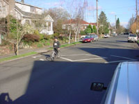 A man rides a bicycle over one of the speed humps.