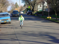 A man rides his bicycle along Clinton Street. A speed table is visible in the background.